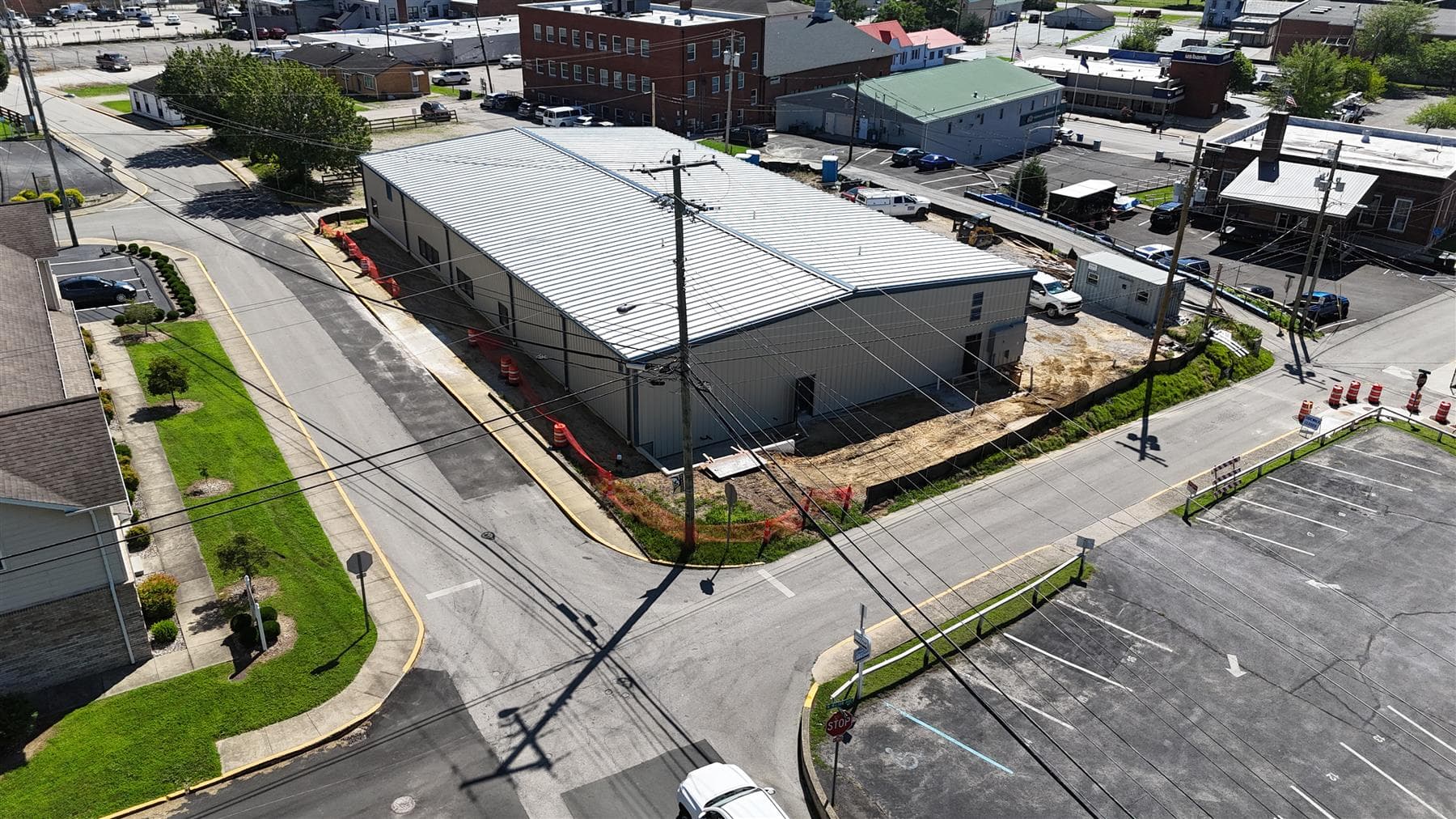 Front aerial of the enclosed building and gravel site, July 2026